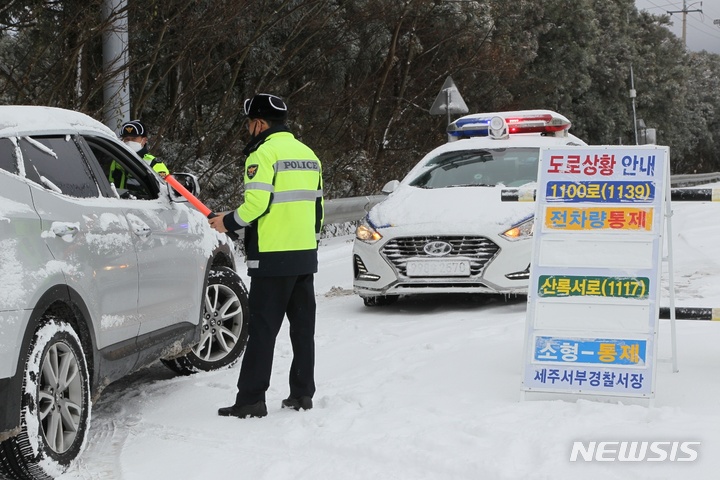 [제주=뉴시스] 제주 도내 한 도로에서 경찰관이 차량을 통제하고 있다. (사진=뉴시스DB)