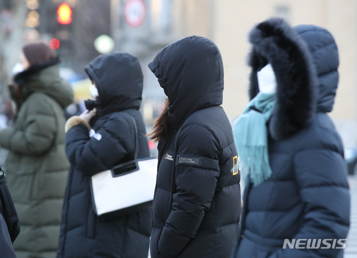 [서울=뉴시스] 조수정 기자 = 전국 대부분 지역에 한파특보가 발효된 지난 27일 오전 서울 세종로 사거리에서 시민들이 두꺼운 외투를 입고 출근길 발걸음을 재촉하고 있다. 2021.12.27. chocrystal@newsis.com