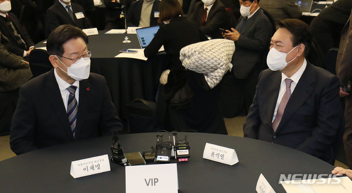 [서울=뉴시스] 국회사진기자단 = 이재명 더불어민주당 대선 후보, 윤석열 국민의힘 대선 후보가 27일 서울 중구 프레스센터에서 한국지방신문협회 주최로 열린 지방자치대상 및 한국지역발전대상 시상식에 참석해 대화하고 있다. 2021.12.27. photo@newsis.com