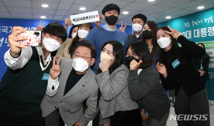 [서울=뉴시스] 국회사진기자단 = 이재명 더불어민주당 대선 후보가 28일 오전 서울 영등포 한국사회복지사협회에서 열린 '복지국가실천연대 간담회 - 청년 그리고 사회복지사를 만나다' 행사에서 참석자들과 기념 사진을 찍고 있다. 2021.12.28. photo@newsis.com