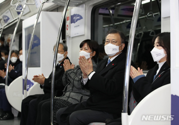 [울산=뉴시스] 김진아 기자 = 문재인 대통령이 28일 울산 태화강역에서 열린 동남권 4개 철도건설사업 개통식을 마친 뒤 부산 일광역으로 향하는 광역전동차를 시승, 박수를 치고 있다. 2021.12.28. bluesoda@newsis.com