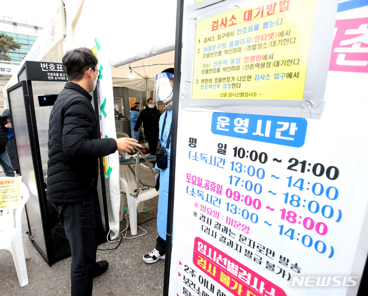 [서울=뉴시스] 조수정 기자 = 지난해 12월27일 서울 서대문구청 자치행정팀 강태호 주무관이 서울 신촌기차역 공영주차장 코로나19 임시선별검사소에서 현장 근무자들과 대화를 나누고 있다. 2022.01.01. chocrystal@newsis.com