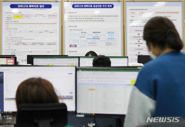 [서울=뉴시스] 조수정 기자 = 지난해 12월 27일 서울 서대문구청 코로나19 재택치료 전담 TF 사무실에서 직원들이 재택치료자들의 상황을 확인하고 있다. 2022.01.01. chocrystal@newsis.com