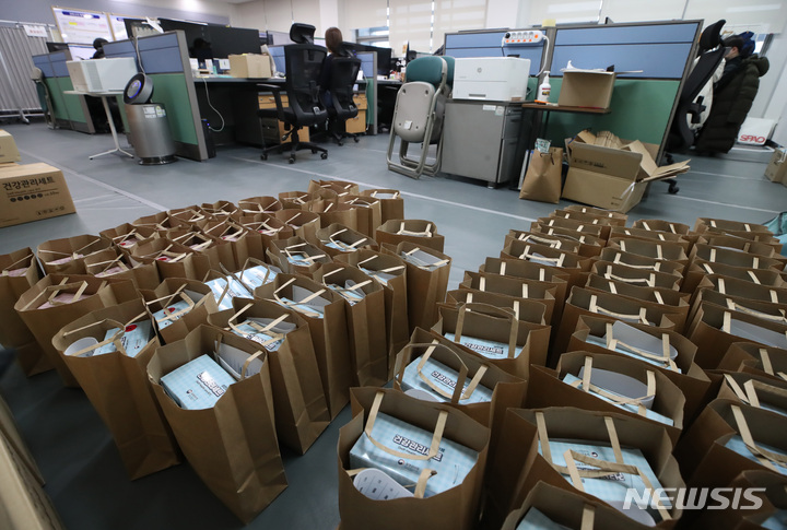 [서울=뉴시스] 조수정 기자 = 지난해 12월 27일 서울 서대문구청 코로나19 재택치료 전담 TF 사무실에 재택치료자들에게 지급하는 건강관리세트가 쌓여 있다. 세트에는 의약품, 산소포화도 측정기, 체온계, 손소독제, 세척용 소독제 등이 들어있다. 2022.01.01. chocrystal@newsis.com