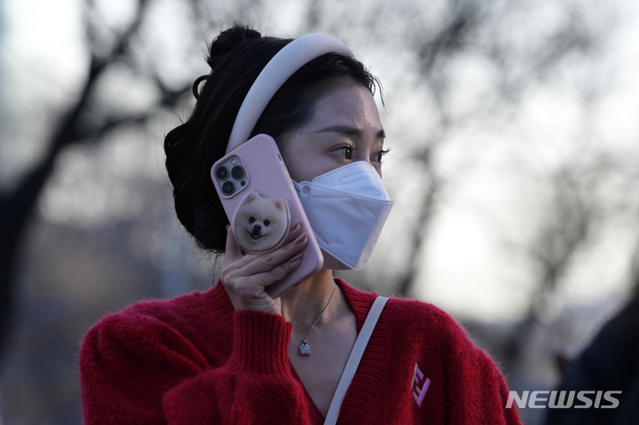 [베이징=AP/뉴시스] 중국 규제당국이 제안한 미성년자 스마트폰 사용 규제로 인해 중국 기술기업들의 주가가 하락했다고 지난 4일(현지시간) 영국 BBC는 보도했다. 사진은 베이징에서 스마트폰을 사용하고 있는 한 여성 2023.08.07.  