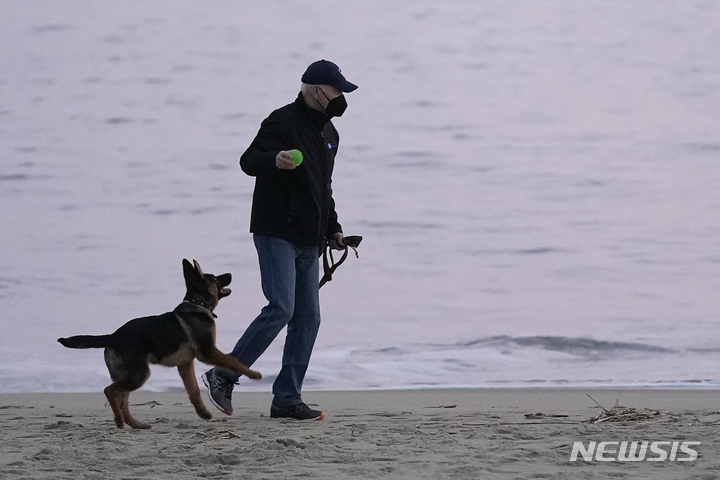 [레호보스비치=AP/뉴시스] 조 바이든 미국 대통령이 지난 2021년 12월28일(현지시간) 미 델라웨어주 레호보스 비치에서 반려견 커맨더와 산책하고 있다. 2021.12.29.