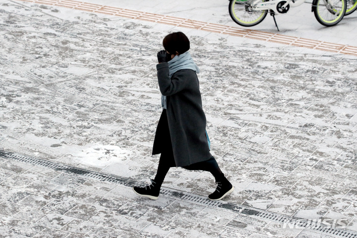 [서울=뉴시스] 김병문 기자 = 눈이 내린 29일 오전 서울 중구 시내에서 시민이 출근길을 하고 있다. 2021.12.29. dadazon@newsis.com