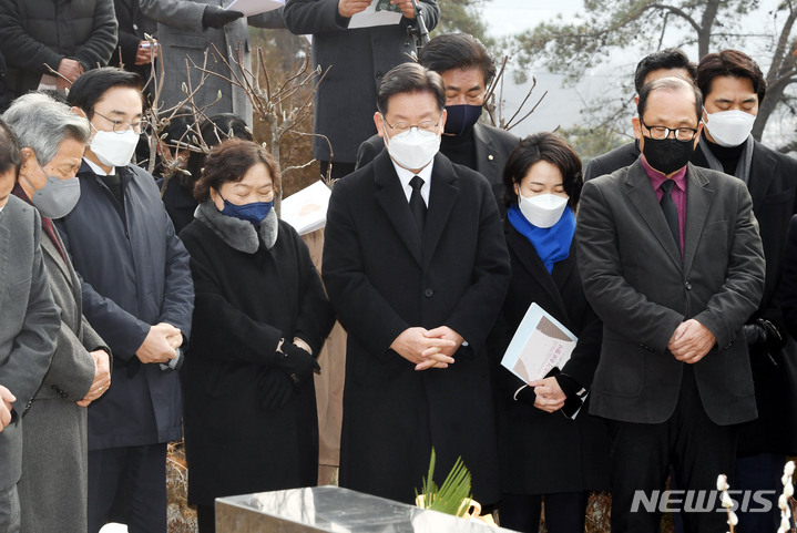 [서울=뉴시스] 국회사진기자단 = 이재명 더불어민주당 대선후보가 29일 오전 경기 남양주시 마석 모란공원 묘역에서 열린 민주주의자 고 김근태선생 10주기 추모행사에 참석해 묵념 하고 있다. 2021.12.29. photo@newsis.com