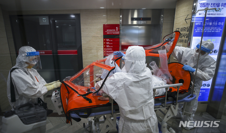 [서울=뉴시스] 서울 광진구 혜민병원에서 의료진들이 코로나19 환자를 이송하고 있다. (사진= 뉴시스 DB) jhope@newsis.com