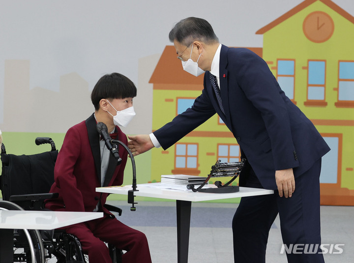 [공주=뉴시스] 김진아 기자 = 문재인 대통령이 29일 충남 공주시 공주대학교 옥룡캠퍼스에서 열린 공주대학교 부설 특수학교 설립 간담회를 마친 뒤 표형민 맑은소리 하모니카 앙상블 단원과 인사하고 있다. 2021.12.29. bluesoda@newsis.com