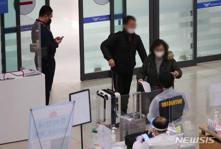 [인천공항=뉴시스] 배훈식 기자 = 코로나19 오미크론 변이 바이러스 확산을 막기위한 해외유입관리강화 조치 4주 연장이 결정된 29일 오후 인천국제공항 제1터미널 입국장에 해외 입국자들이 들어오고 있다. 해외유입관리강화 조치는 남아프리카공화국을 비롯한 아프리카 국가 1개국 입국제한과 에티오피아발 항공편 운항 중단, 접종자 격리 유지 등이다. 2021.12.29. dahora83@newsis.com