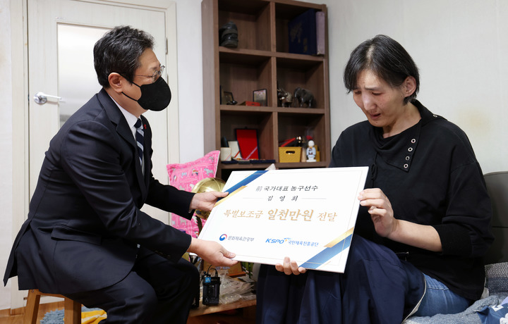 [서울=뉴시스] 고승민 기자 = 황희 문화체육관광부 장관이 29일 말단비대증 투병중인 김영희 전 여자농구 국가대표의 자택을 찾아 김 씨에게 특별보조금을 지급하고 있다. (사진=문화체육관광부 제공) 2021.12.29. photo@newsis.com *재판매 및 DB 금지