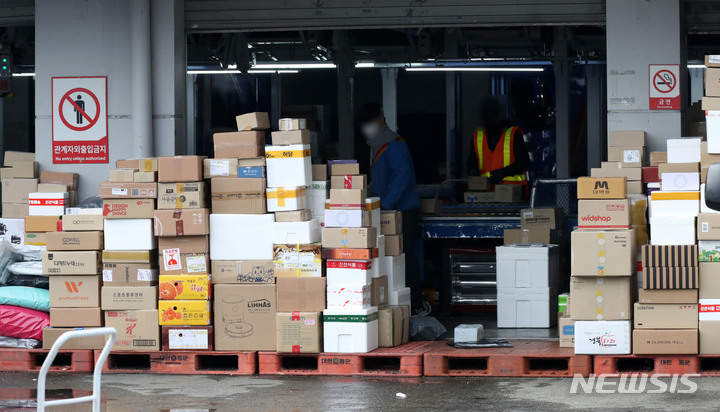 [서울=뉴시스] 고범준 기자 = 전국택배노동조합(택배노조) CJ대한통운지부가 사회적 합의에 따른 택배비 인상분을 공정하게 분배할 것을 요구하며 무기한 파업에 들어간 지난 29일 오후 서울의 한 CJ대한통운 물류센터에서 직원들이 택배분류 작업을 하고 있다. 2021.12.29. bjko@newsis.com