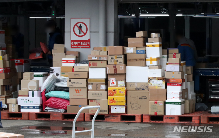 [서울=뉴시스] 고범준 기자 = 전국택배노동조합(택배노조) CJ대한통운지부가 사회적 합의에 따른 택배비 인상분을 공정하게 분배할 것을 요구하며 무기한 파업에 들어간 29일 오후 서울의 한 CJ대한통운 물류센터에서 직원들이 택배분류 작업을 하고 있다. 2021.12.29. bjko@newsis.com