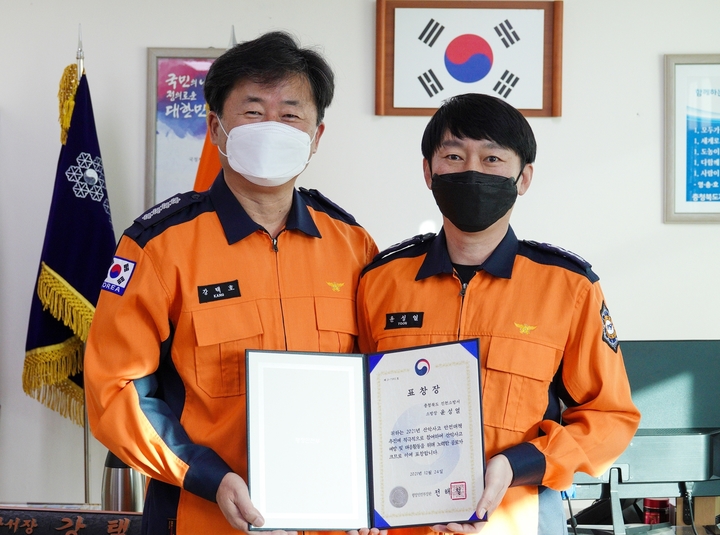 [진천=뉴시스] 강신욱 기자 = 진천소방서 윤성열(오른쪽) 소방장이 강택호 진천소방서장으로부터 행정안전부 장관상을 전수받고 있다. (사진=진천소방서 제공) 2021.12.30. photo@newsis.com *재판매 및 DB 금지