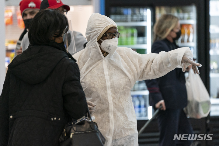 [워싱턴DC(미국)=AP/뉴시스]29일(현지시간) 미국 로널드레이건 워싱턴 국제공항에서 마스크, 장갑 등 개인 감염 보호장비를 착용한 시민들이 대화하고 있다. 2021.12.30.