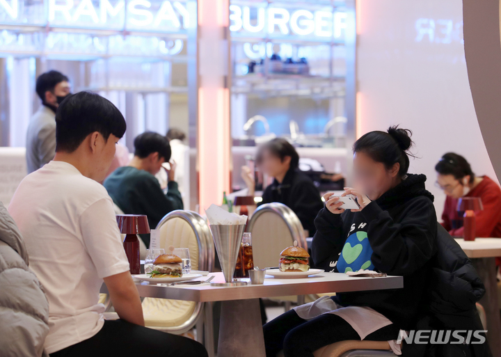 [서울=뉴시스] 조성우 기자 = 30일 오전 서울 송파구 잠실 롯데월드몰에 프리 오픈한 스타 셰프 고든 램지의 하이엔드 버거 레스토랑인 '고든 램지 버거'에서 고객들이 버거를 먹고 있다. 2021.12.30. xconfind@newsis.com