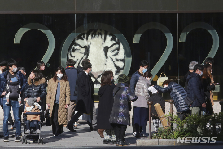 [도쿄(일본)=AP/뉴시스]지난 30일 일본 도쿄에서 코로나19 감염 예방을 위해 마스크를 쓴 시민들이 거리를 걷고 있따. 2021.12.31