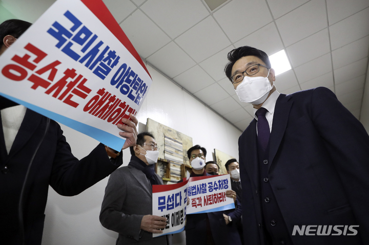 [서울=뉴시스] 최진석 기자 = 김진욱 고위공직자범죄수사처(공수처) 처장이 30일 서울 국회에서 열린 법제사법위원회 회의에 출석해 공수처 해체 촉구 피켓을 들고 의원총회를 하고 있는 국민의힘 의원들에게 인사를 위해 이동하고 있다. 2021.12.30. myjs@newsis.com