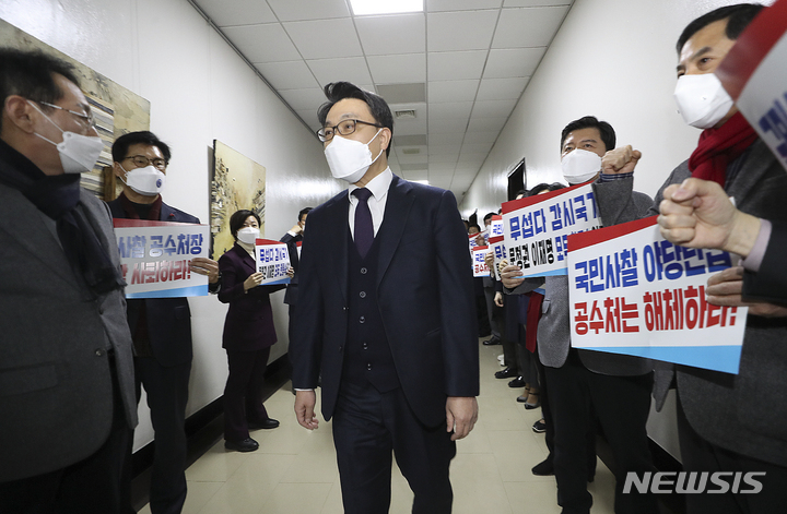 [서울=뉴시스] 최진석 기자 = 김진욱 고위공직자범죄수사처(공수처) 처장이 30일 서울 국회에서 열린 법제사법위원회 회의에 출석해 공수처 해체 촉구 피켓을 들고 의원총회를 하고 있는 국민의힘 의원들에게 인사를 위해 이동하고 있다. 2021.12.30. myjs@newsis.com