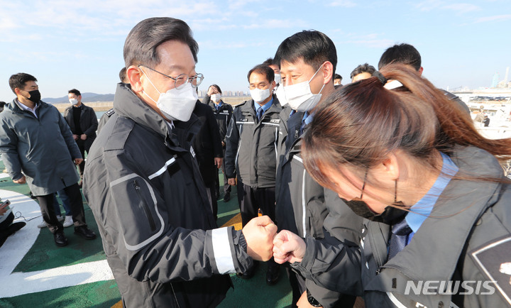[인천=뉴시스] 국회사진기자단 = 이재명 더불어민주당 대선후보가 30일 인천해양경찰서 전용부두에 위치한 서해5도 특별경비단을 방문해 경비함에서 대원들과 인사를 나누고 있다. 2021.12.30. photo@newsis.com