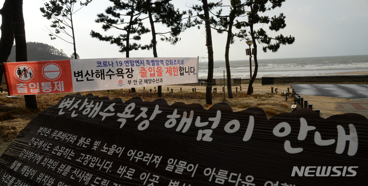 [부안=뉴시스] 김얼 기자 = 전북지역 곳곳이 코로나19 확산 방지를 위해 해넘이와 해맞이 명소의 행사가 취소되고 있는 30일 전북 부안군 변산 해수욕장에 출입 통제를 알리는 안내문이 붙어 있다. 2021.12.30. pmkeul@nwsis.com