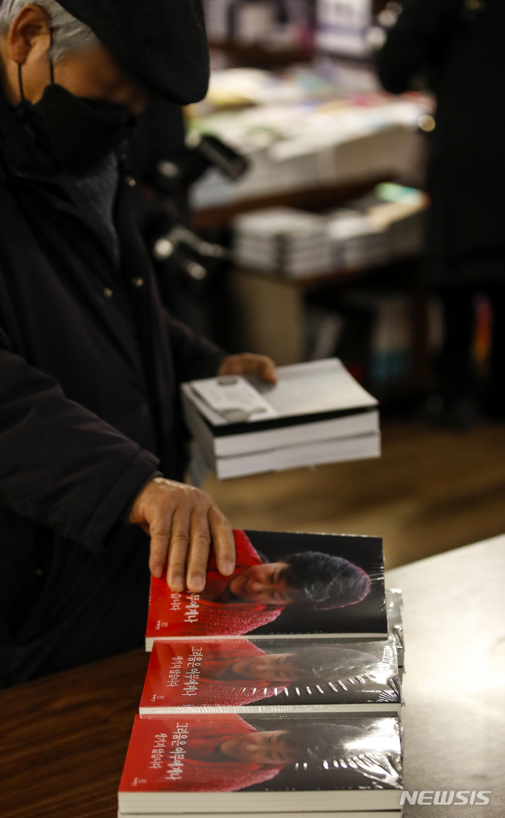 [서울=뉴시스] 정병혁 기자 = 30일 오후 서울 종로구 교보문고 광화문점을 찾은 시민들이 유영하 변호사와 가로세로연구소(가세연)가 함께 박근혜 전 대통령의 옥중 서신을 책으로 옮겨 출간한 '그리움은 아무에게나 생기지 않습니다'를 구매하고 있다. 2021.12.30. jhope@newsis.com