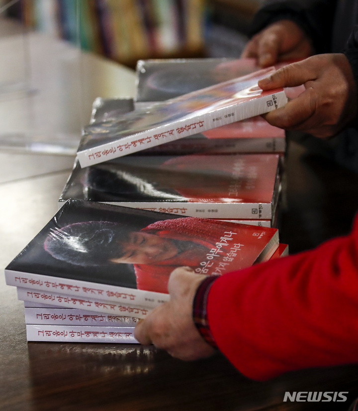 [서울=뉴시스] 정병혁 기자 = 30일 오후 서울 종로구 교보문고 광화문점을 찾은 시민들이 유영하 변호사와 가로세로연구소(가세연)가 함께 박근혜 전 대통령의 옥중 서신을 책으로 옮겨 출간한 '그리움은 아무에게나 생기지 않습니다'를 구매하고 있다. 2021.12.30. jhope@newsis.com