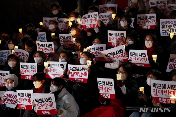 [서울=뉴시스] 정병혁 기자 = 전국민중행동 관계자 및 시민들이 30일 오후 서울 중구 파이낸스빌딩 앞 계단에서 열린 박근혜사면반대, 문재인정부규탄 시민발언대에서 촛불과 피켓을 들고 있다. 2021.12.30. jhope@newsis.com