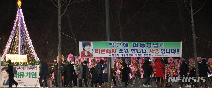 [서울=뉴시스] 조수정 기자 = 문재인 정부 5차 특별사면 대상인 박근혜 전 대통령 석방을 앞두고 지난 30일 오후 박 전 대통령이 입원하고 있는 서울 강남구 삼성서울병원 앞에서 지지자들이 석방 환영을 위해 모여 있다. 병원 인근에는 지지자들의 석방 환영 및 쾌유 기원 화환과 현수막이 늘어서 있다. 2021.12.30. chocrystal@newsis.com