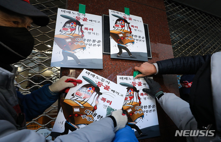 [서울=뉴시스] 권창회 기자 = 민주노총 전국택배노동조합 CJ대한통운 택배 노동자들이 31일 오후 서울 중구 CJ대한통운 본사 앞에서 CJ대한통운을 규탄하며 손피켓을 붙이고 있다. 2021.12.31. kch0523@newsis.com