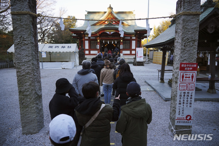 [요코하마=AP/뉴시스] 1일 일본 도쿄 인근 요코하마의 한 신사에 새해를 맞아 소원을 비는 기도를 하려는 시민들이 줄 지어 서 있다. 2022.01.01.