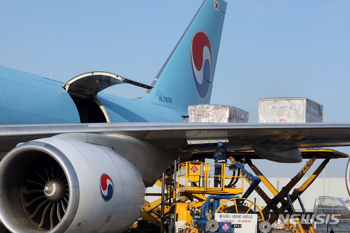 [인천공항=뉴시스] 김명원 기자 = 임인년(壬寅年) 새해 첫 날인 1일 오전 인천공항 대한항공 화물터미널에서 근무자들이 수출 화물을 싣고 있다. (공동취재사진) 2022.01.01. photo@newsis.com