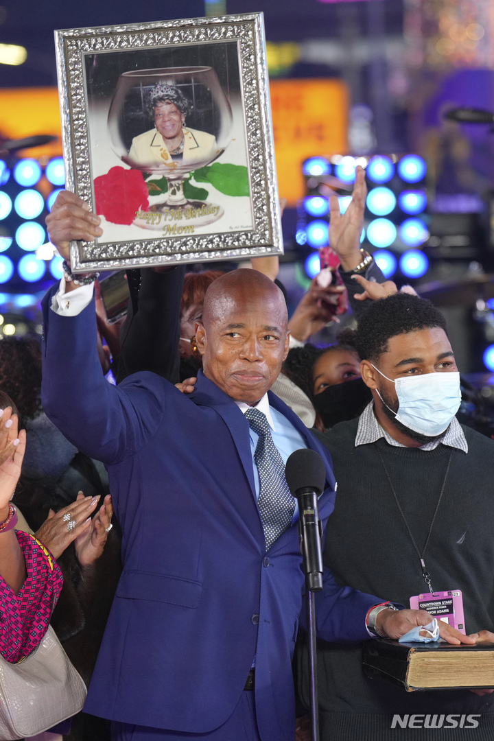 [ 뉴욕= AP/뉴시스] 에릭 애덤스 새 뉴욕시장이 타임스 스퀘어에서 송년행사가 끝난 1일 0시에 취임식을 거행하면서 어머니의 사진을 들어보이고 있다.&nbsp; 