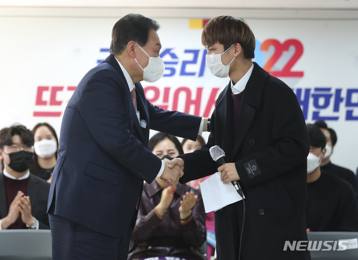 [서울=뉴시스] 최진석 기자 = 윤석열 국민의힘 대선 후보가 1일 서울 여의도 대하빌딩에서 열린 국민의힘 선대위 신년인사회에 참석해 젠더 관련 발언을 마친 곽승용 청년보좌역을 격려하고 있다. 2022.01.01. myjs@newsis.com