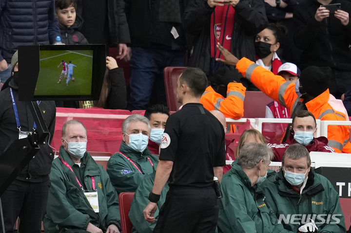 [런던=AP/뉴시스] 영국 런던 에미리츠 스타디움에서 열린 아스날과 맨체스터 시티의 2021~22 잉글랜드 프리미어리그 경기에서 스튜어트 아트웰 주심이 후반 페널티킥 여부를 판정하기 위해 모니터를 바라보고 있다. 2022.01.02.