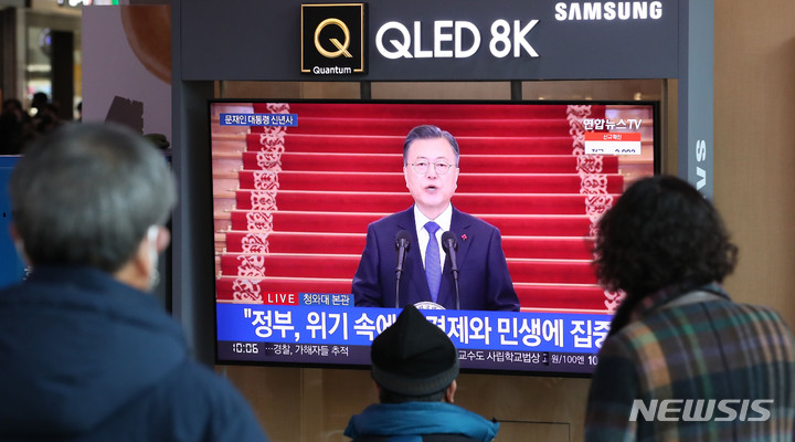 [서울=뉴시스] 권창회 기자 = 3일 오전 서울 중구 서울역 대합실에서 시민들이 문재인 대통령 신년사를 시청하고 있다. 2022.01.03. kch0523@newsis.com