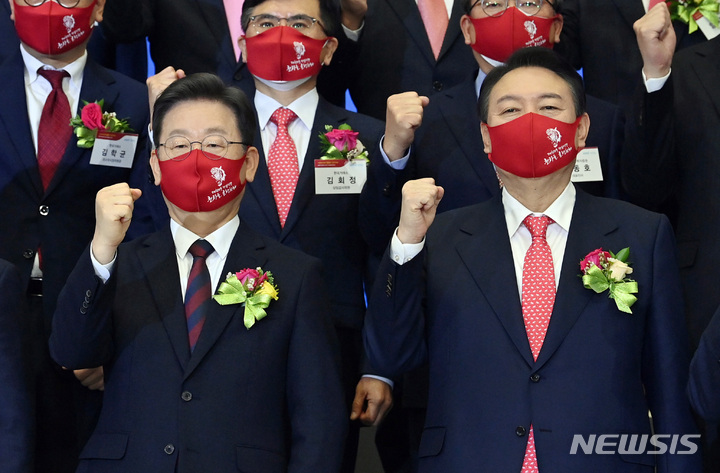 [서울=뉴시스] 국회사진기자단 = 이재명 더불어민주당 대선 후보, 윤석열 국민의힘 대선 후보가 3일 서울 영등포구 한국거래소에서 열린 2022년 증권·파생상품시장 개장식에서 참석자들과 기념촬영을 하고 있다. 2022.01.03. photo@newsis.com