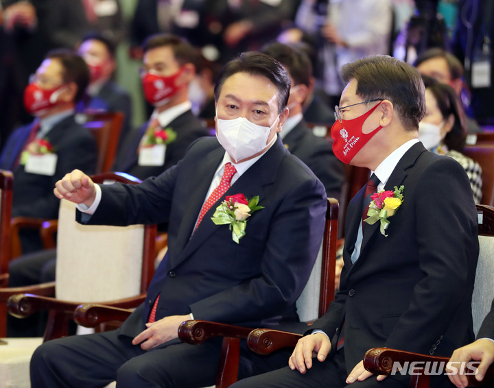 [서울=뉴시스] 국회사진기자단 = 이재명 더불어민주당 대선 후보, 윤석열 국민의힘 대선 후보가 3일 서울 영등포구 한국거래소에서 열린 2022년 증권·파생상품시장 개장식에 참석해 대화하고 있다. 2022.01.03. photo@newsis.com