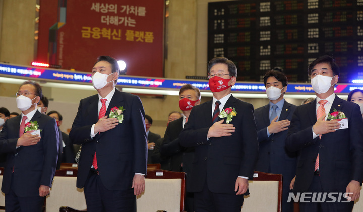 [서울=뉴시스] 국회사진기자단 = 이재명 더불어민주당 대선 후보, 윤석열 국민의힘 대선 후보가 3일 서울 영등포구 한국거래소에서 열린 2022년 증권·파생상품시장 개장식에 참석해 국민의례를 하고 있다. 2022.01.03. photo@newsis.com