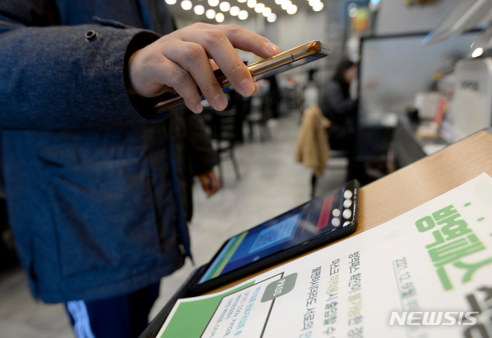 [광주=뉴시스] 김혜인 기자 = 코로나19 백신 방역패스 유효기간 제도가 시행된 3일 오후 광주 동구 동명동 한 식당가에서 손님들이 QR코드를 인증하고 있다. 2021.01.03.hyein0342@newsis.com