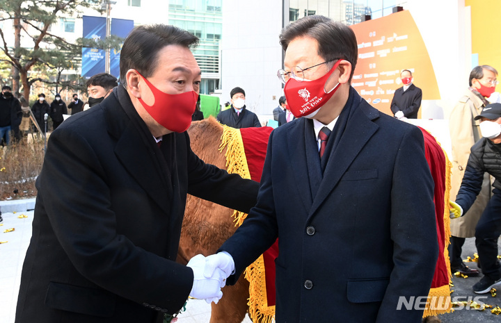 [서울=뉴시스] 국회사진기자단 = 이재명 더불어민주당 대선 후보, 윤석열 국민의힘 대선 후보가 3일 서울 여의도 한국거래소에서 열린 2022 증시대동제에 참석해 악수하고 있다. 2022.01.03. photo@newsis.com