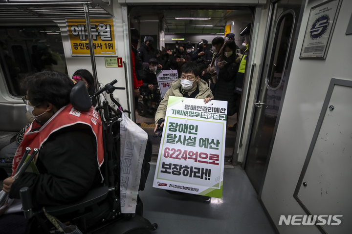 [서울=뉴시스] 정병혁 기자 = 전국장애인차별철폐연대 관계자들이 지난달 3일 오후 서울 종로구 광화문역 5호선 승강장에서 기획재정부 장애인권리예산 반영 촉구에 대한 입장발표 기자회견 마친 뒤 이동권 보장 정책, 교육권 연내제정 등을 요구하며 지하철에 탑승하고 있다. 2022.01.03. jhope@newsis.com