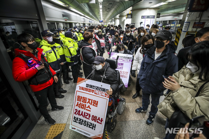 [서울=뉴시스] 정병혁 기자 = 전국장애인차별철폐연대 관계자들이 지난달 3일 오후 서울 종로구 광화문역 5호선 승강장에서 기획재정부 장애인권리예산 반영 촉구에 대한 입장발표 기자회견을 마친 뒤 이동권 보장 정책, 교육권 연내제정 등을 요구하며 지하철에 탑승하고 있다. 2022.01.03. jhope@newsis.com