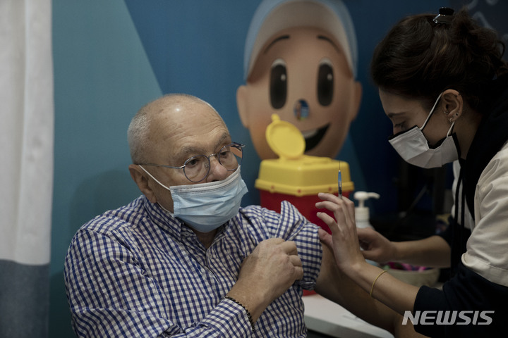 [예루살렘=AP/뉴시스] 3일(현지시간) 이스라엘 예루살렘의 한 보건소에서 한 주민이 코로나19 백신 4차 접종을 하고 있다. 이스라엘 정부는 60세 이상 고령층과 의료진을 대상으로 4차 접종을 시작했다. 2022.01.04.