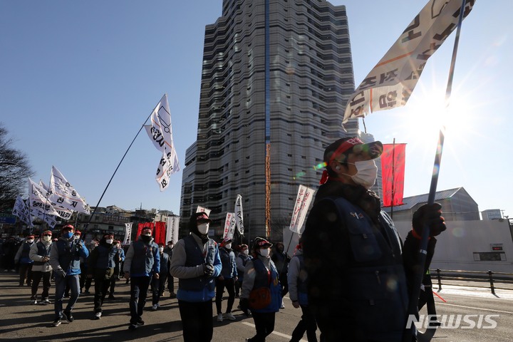 [서울=뉴시스] 백동현 기자 = 민주노총 서비스연맹 전국택배노동조합 조합원들이 4일 오후 서울 중구 CJ 본사 앞에서 CJ대한통운 총파업 결의대회를 마치고 CJ대한통운 본사 방향으로 행진하고 있다. 2022.01.04. livertrent@newsis.com