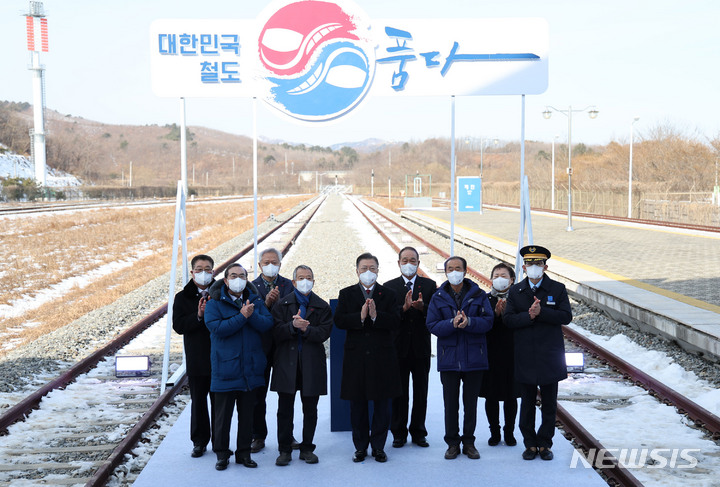 [고성=뉴시스] 전진환 기자 = 문재인 대통령이 5일 오전 강원 고성군 제진역에서 열린 동해선 강릉~제진 철도건설 착공식이 끝난 뒤 서명판에 서명한 뒤 참석자들과 기념촬영을 하고 있다. 2022.01.05. amin2@newsis.com