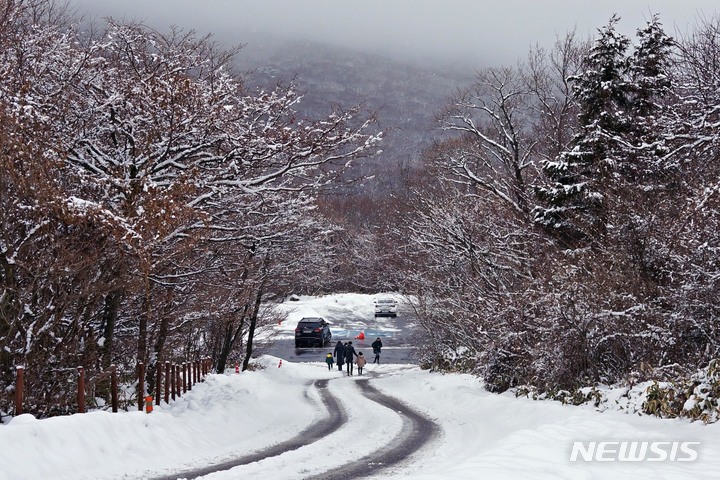 [제주=뉴시스] 이산책 기자 = 밤사이 내린 눈으로 인해 지난 5일 오전 제주 한라산 일부 도로가 통제되면서 여행객들이 차를 세워둔 채 설경을 즐기고 있다. 2022.01.05. photo@newsis.com