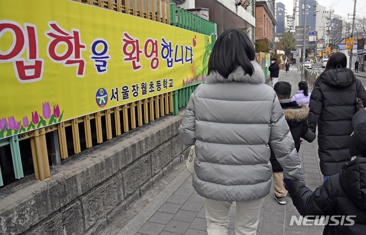 [서울=뉴시스] 고승민 기자 = 2022학년도 신입생 예비소집일인 지난달 5일 오후 서울 성북구 장월초등학교를 찾은 예비 초등학생과 학부모가 입학 서류 작성을 하기 위해 학교로 향하고 있다. (공동취재사진) 2022.02.25. photo@newsis.com