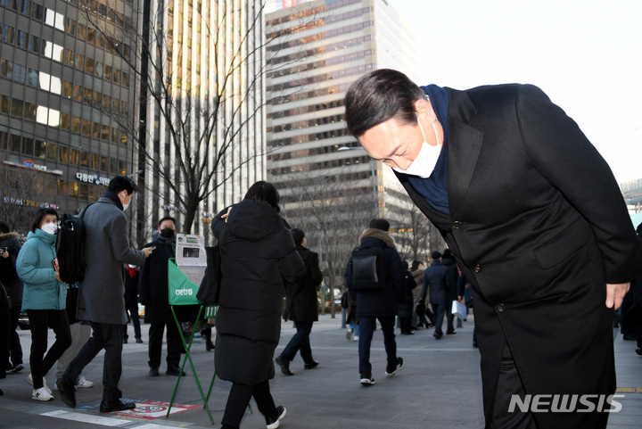 [서울=뉴시스] 국회사진기자단 = 윤석열 국민의힘 대선 후보가 6일 서울 여의도역 출구에서 출근하는 시민들에게 인사하고 있다. 2022.01.06. photo@newsis.com